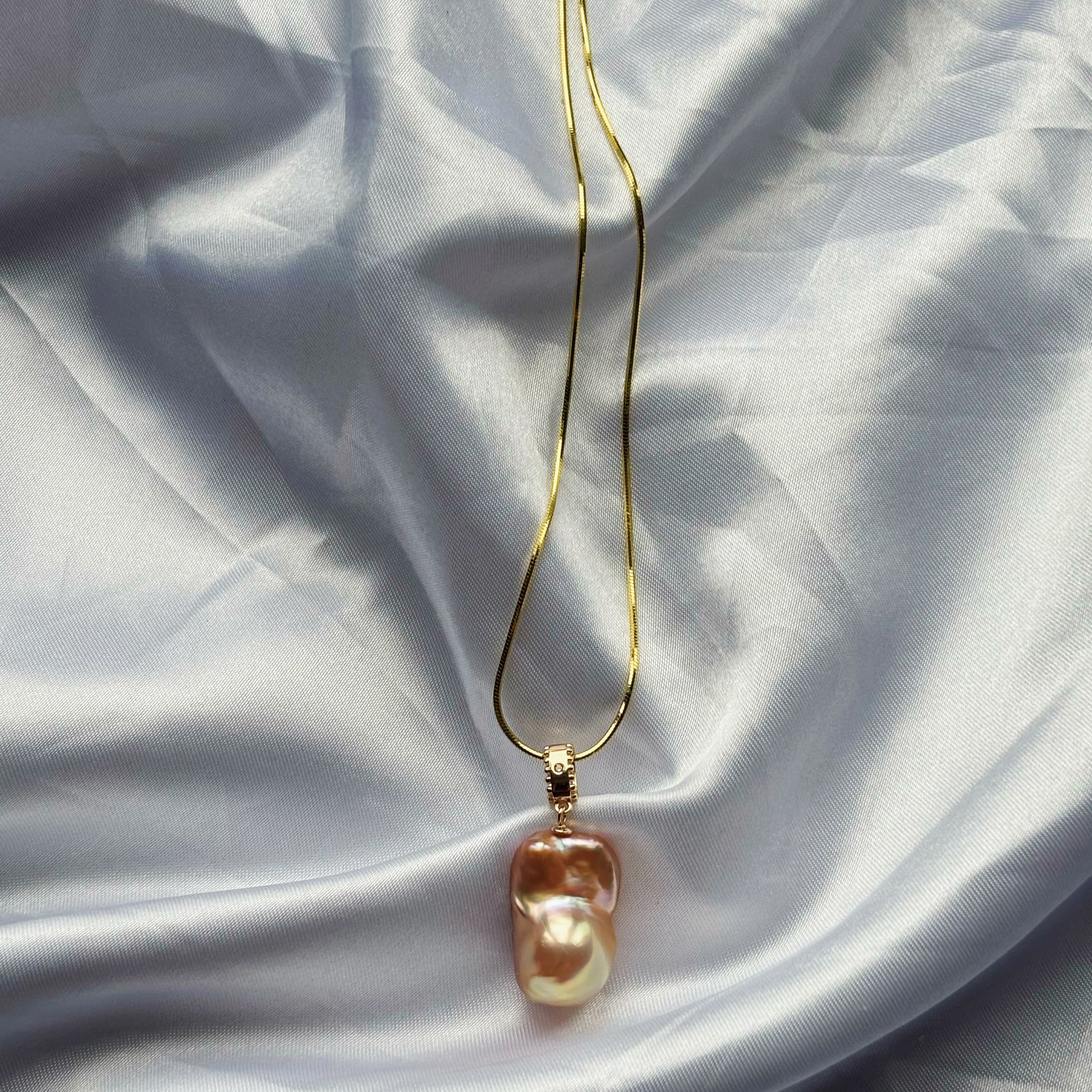 Nature's Calm Baroque Pearl necklace with a gold chain and a brown-and-cream baroque pearl pendant.