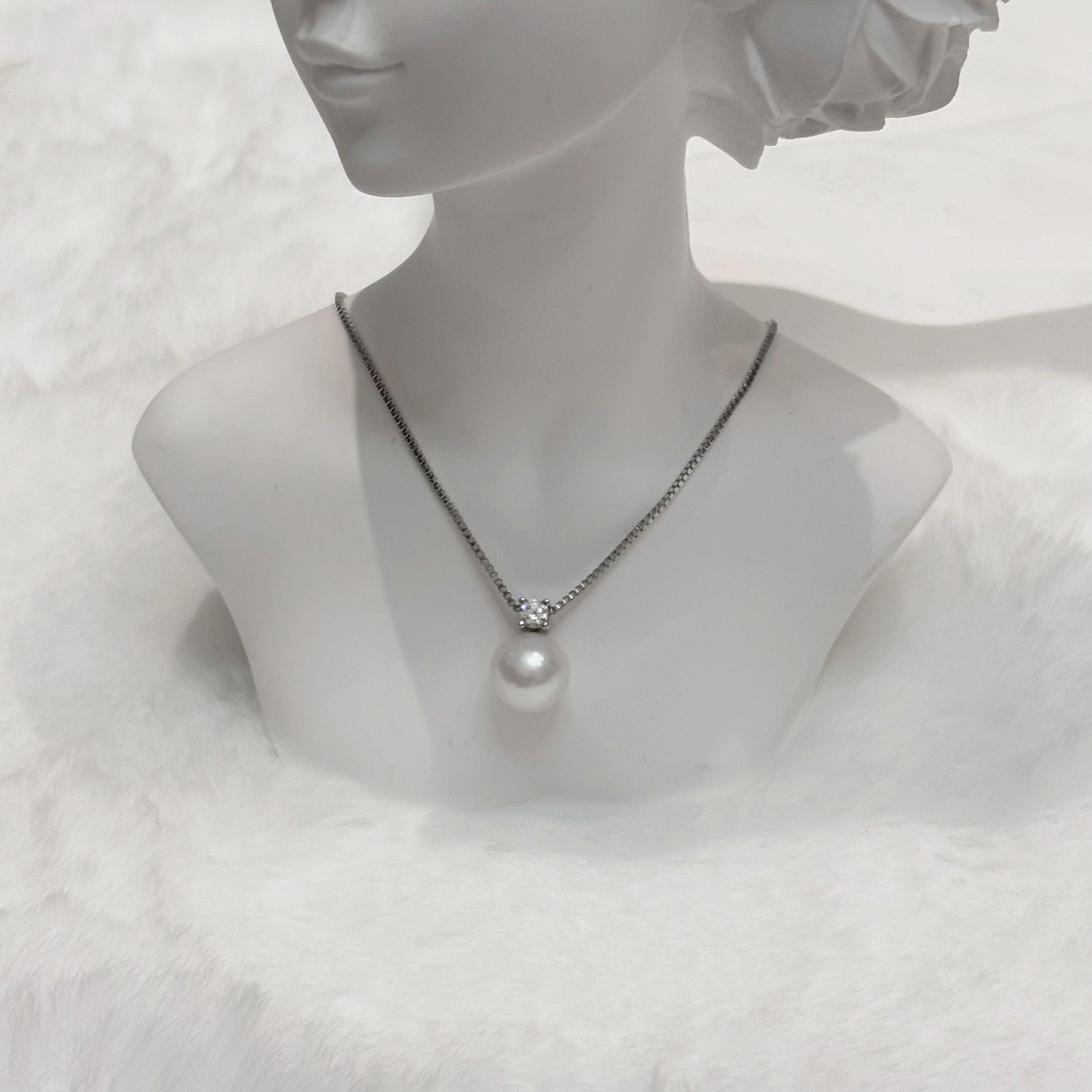 Gentle Healing Necklaces: silver chain with crystal pendant and single hanging pearl on a mannequin bust.