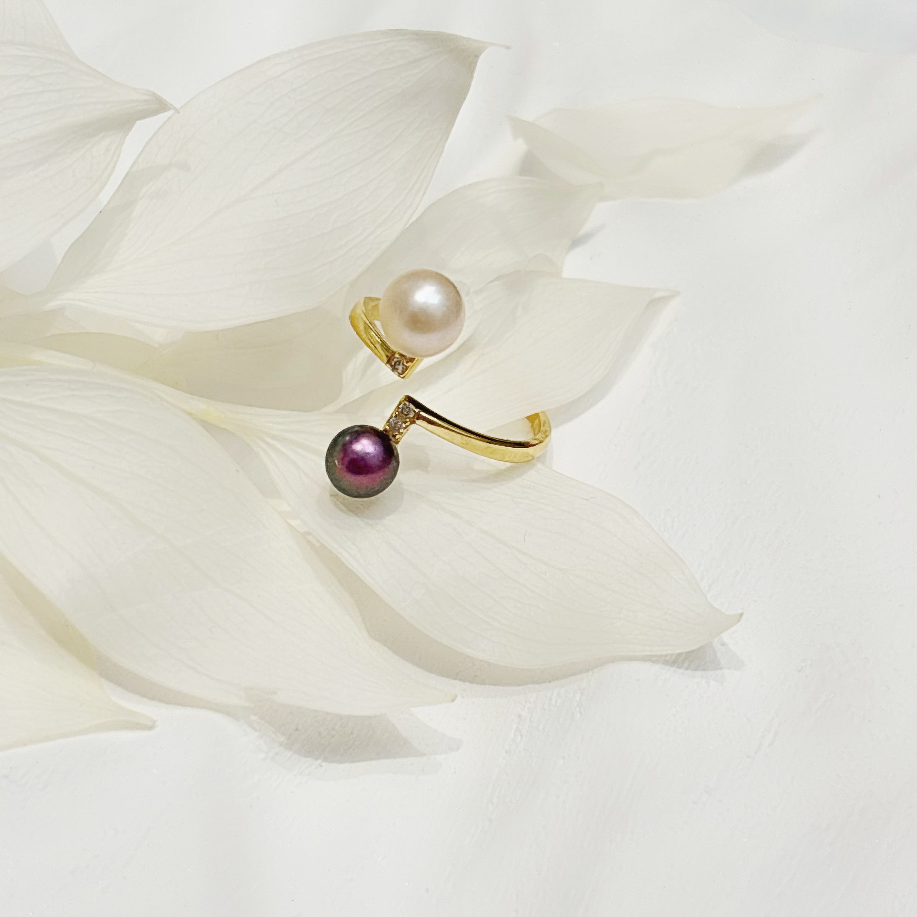 Ocean Power Rings: gold open ring with pearl and purple bead on white petals.